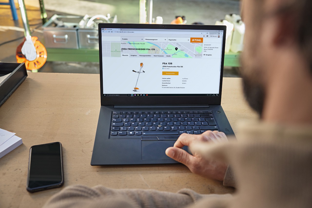 Mann sitzt vor dem aufgeklappten Laptop und prüft den Gerätestand bei STIHL